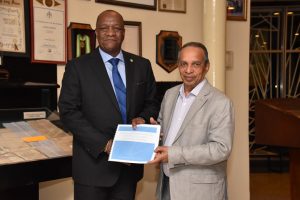 Minister of State,  Joseph Harmon (left) receives a copy of the Private Sector Commission Action Plan for the Sustainable Development of Guyana from PSC’s Chairman, Eddie Boyer. (Ministry of the Presidency photo)