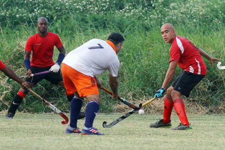 GHB President Philip Fernandez (number 7) battles three Old Fort players in their second division clash yesterday.