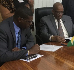 Seated from left are Ministers David Patterson and Winston Jordan