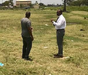 Guyana Football Federation president Wayne Forde, right, inspects the site for the proposed erection of a regional football facility in New Amsterdam.