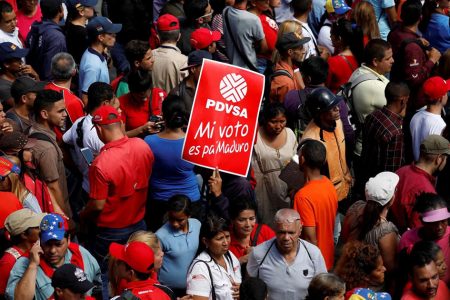 The corporate logo of the state oil company PDVSA is seen in a banner that reads “My vote is for Maduro” during a rally with Venezuela’s President Nicolas Maduro outside the National Electoral Council (CNE) headquarters after he registered his candidacy for re-election, in Caracas, Venezuela February 27, 2018. REUTERS/Marco Bello/File Photo