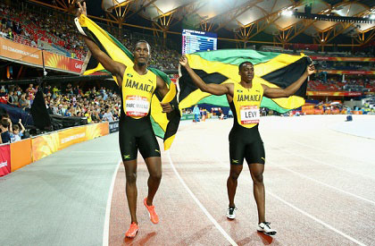Winner Ronald Levy (right) and Jamaican teammate Hansle Parchment celebrate their one-two in the men’s sprint hurdles.  