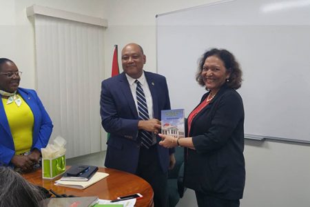 Minister of Natural Resources, Raphael Trotman (centre) presents Word Bank Director for the Caribbean Tahseen Khan with a token of appreciation as Minister within his ministry, Simona Broomes looks on. 