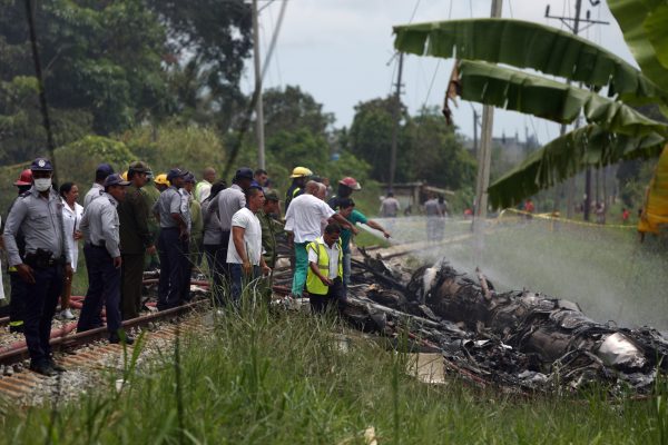 Rescue team members work in the wreckage of a Boeing 737 plane that crashed in the agricultural area of Boyeros, around 20 km (12 miles) south of Havana, shortly after taking off from Havana's main airport in Cuba, May 18, 2018. REUTERS/Alexandre Meneghini