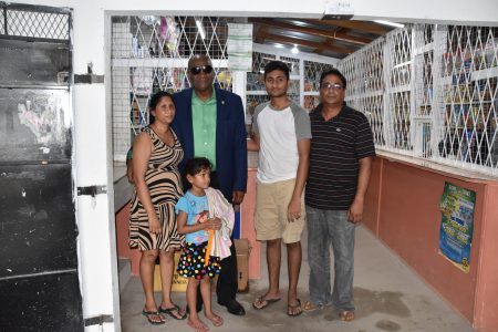 Minister of State Joseph Harmon with Samantha Thakurdeen (at left), her husband Naresh Persaud (at right) and the couple’s children. (Ministry of the Presidency photo)