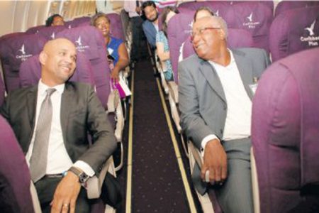 Chief executive officer Caribbean Airlines, Garvin Madera, left is joined by chairman of the Airports Authority of T&T Keith Thomas as they relax in the economy cabin of the Boeing 737 jet aircraft, during the launch of the Caribbean Plus at the Head Office, Golden Grove Road, Piarco yesterday.