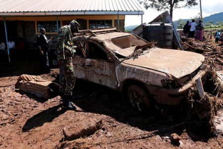 A military officer assesses a damaged car after a dam burst, which unleashed water at nearby homes, in Solio town near Nakuru, Kenya May 10, 2018. (Reuters photo)