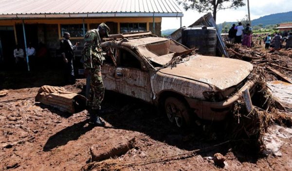 A military officer assesses a damaged car after a dam burst, which unleashed water at nearby homes, in Solio town near Nakuru, Kenya May 10, 2018. (Reuters photo)