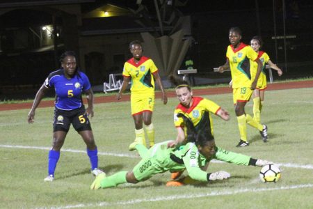 Barbados goalkeeper Rhea Holder gathers the ball from  Guyana’s Marian El-Masri during their scoreless draw in the CONCACAF Women’s Qualifiers at the National Track and Field Centre, Leonora last night. (Orlando Charles photo) 