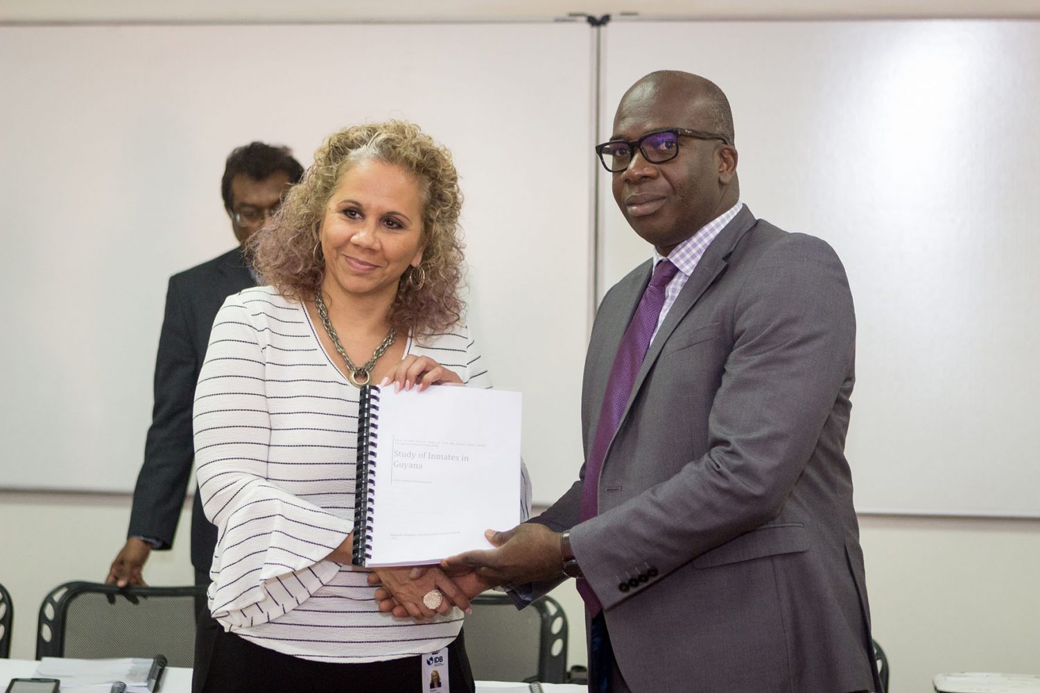 Sophie Makonnen (left)  Resident Representative of the IDB handing over the report to Dr. Clement Henry,  Citizens Security Strengthening Programme Project Manager.