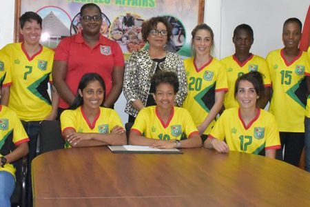 Minister Within The Ministry of Indigenous Peoples’ Affairs, Valerie Garrido-Lowe, posing with several members of the Lady Jaguars team at her Thomas Street Office.