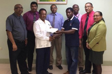  Malteenoes Sports Club president Winston Semple receives the donation from Seepaul Narine of the New Building Society while representatives of the company and the club look on.

