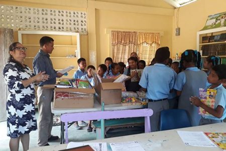 Head of the Learning Resource Development Unit,  Myra Pierre-Moore (left) and District Education Officer, Marti De Souza (second from left) engaging the students of White Water Primary School. (Ministry of Education photo) 