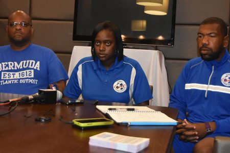 Bermuda Head-Coach Naquita Robinson (centre) addressing the media gathering following their arrival on local shores. Also in the picture are Assistant Coach Vance Brown (left) and Goalkeeper Coach Deshawn Cooper
