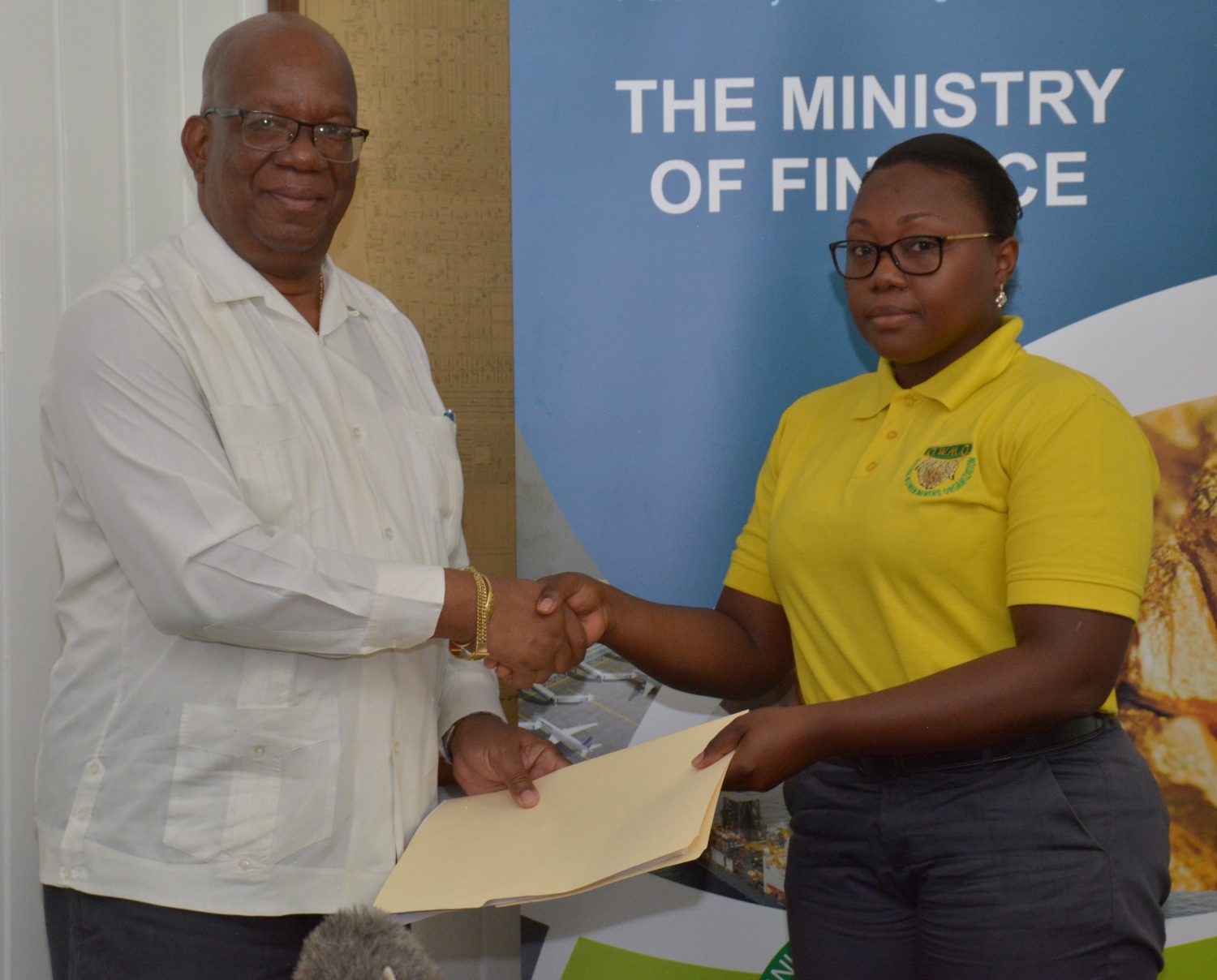 Minister of Finance Winston Jordan (left)  solemnizing the agreement with Urica Primus. (Ministry of Finance photo)