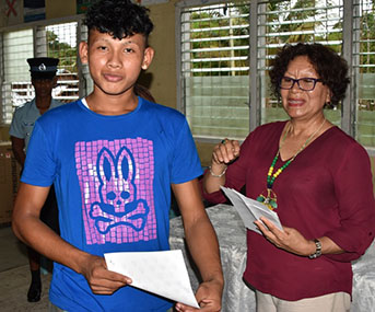 Minister within the Ministry of Indigenous Peoples’ Affairs, Valerie Garrido-Lowe handing over a birth certificate (DPI photo).
