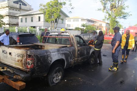 A fireman using a power saw to cut open the bonnet of the vehicle following the fire yesterday afternoon which saw a vehicle belonging to the Georgetown Mayor and City Council going up in flames. 