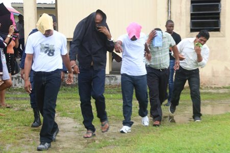 From left in handcuffs are Doodnauth Chattergoon, Rajendra Persaud, Khemraj Lall, Marlon Lawrence and Cleve Thornhill, all of whom were charged yesterday at the Leonora Magistrate’s Court with trafficking cocaine and cannabis.  
