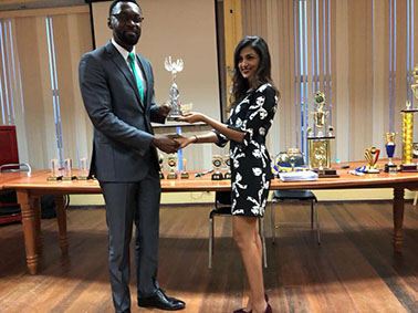 National chess player Yolander Persaud (right) smiles as she receives her tournament trophy from Director of Sport Christopher Jones at the Racquet Centre on Friday, May 25. Persaud, who is also an attorney, won the Women’s Champion of Champions Tournament, which was hosted by the Guyana Chess Federation recently. She has been nominated to represent Guyana at the 2018 FIDE Chess Olympiad in Batumi, Georgia, in September.