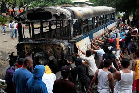 Demonstrators place a burned bus as a barricade. (Reuters photo)