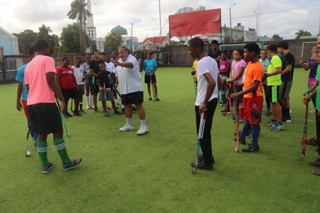 FIH Coach Shiv Jagday (centre) explains a point to junior players at the GCC ground, during a previous visit to Guyana.