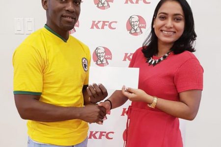 Korean International Chairman Roland Eudoxie receives the sponsorship cheque from KFC Marketing Manager, Lavasti Bhooplall.