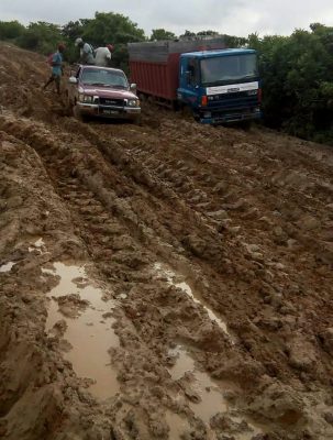 Two trucks can be seen navigating a section of the Onverwagt access road before the rehabilitation works.