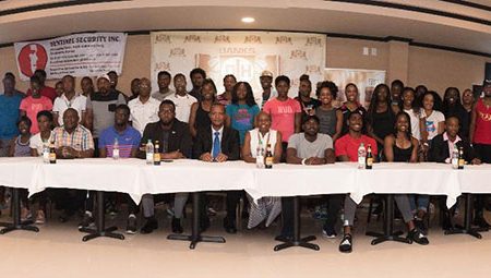 The athletes competing in today’s Aliann Pompey Invitational pose with the principals of the event yesterday at the SleepIn International Hotel and Casino. 