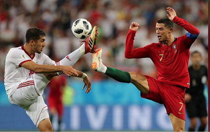 Iran’s Majid Hosseini in action with Portugal’s Cristiano Ronaldo REUTERS/Ivan Alvarado.