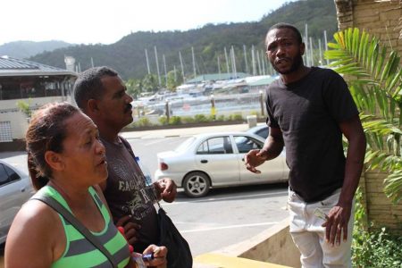 Niria Macano (left) and a Venezuelan man (centre) negotiate with a Trinidadian man (right) about payments for docking boats in Chaguaramas, Trinidad and Tobago, May 24, 2018. Thomson Reuters Foundation/Gregory Scruggs