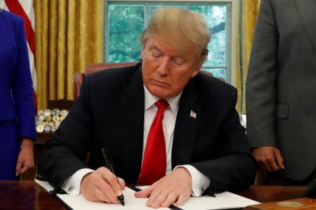 U.S. President Donald Trump signs an executive order on immigration policy in the Oval Office of the White House in Washington, U.S., June 20, 2018.  REUTERS/Leah Millis