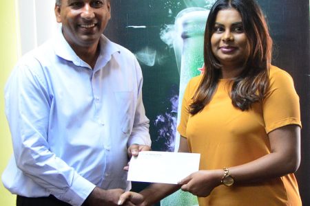Heineken Brand Manager Darshanie Yussuf (right) presenting the sponsorship cheque to Aleem Hussain, President of the Lusignan Golf Club, yesterday at the Ansa McAl Head Office (Orlando Charles photo).
