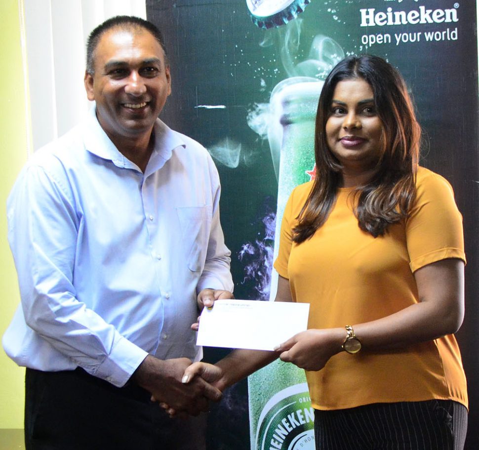 Heineken Brand Manager Darshanie Yussuf (right) presenting the sponsorship cheque to Aleem Hussain, President of the Lusignan Golf Club, yesterday at the Ansa McAl Head Office (Orlando Charles photo).
