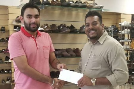 Discount Store CEO Ridwan Khan (left) making the presentation to Guyana Cup representative, Roy Jafarally