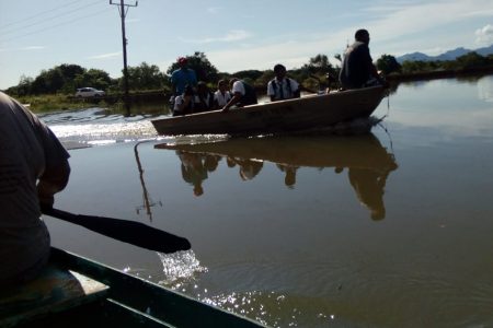 Students being shuttled between Lethem and St. Ignatius Village, via a boat belonging to the Lethem Policing Group, as sections of the area were yesterday inundated by water from the Takutu and Ireng rivers. (Photo courtesy of Erwin Thompson) 