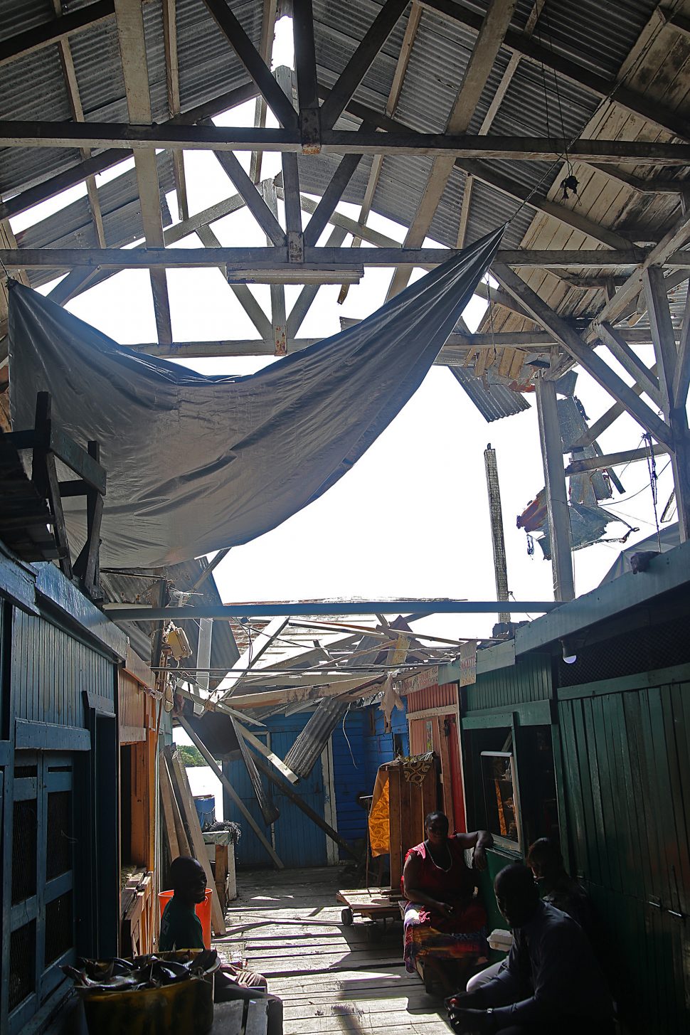 Several zinc sheets resting on vendors’ stalls after falling from the roof.

