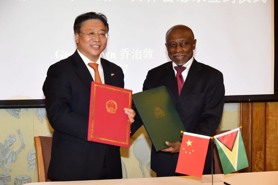 Signed and sealed: China’s Ambassador to Guyana Cui Jianchun and Guyana’s Foreign Affairs Minister Carl Greenidge are all smiles after the signing of a Memorandum of Understanding on cooperation within China’s Silk Road Economic Belt and the 21st Century Maritime Silk Road Initiative. (Ministry of the Presidency photo) 