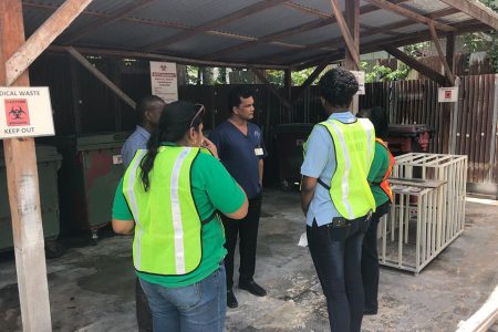 Administrator of the Woodlands Hospital Deonarine Memraj (at centre) speaking with the Environmental Protection Agency team at the storage area yesterday
