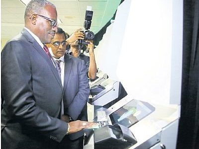 Minister of National Security Edmund Dillon does a fingerprint check at one of the new automated border control system kiosks at Piarco International Airport yesterday.