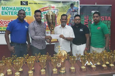 New Era Director Shareef Major receives one of the tournament trophies from Nazr Mohamed while from left, Aubrey Major (Jr), Kenrick Noel and Ansa McAl’s Seweon McGregor, look on.