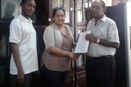 Luandra Jack (left), NAREI’s Engineer looks on as Dr. Oudho Homenauth (right), CEO of NAREI hands over the contract to  Keshiri Gajraj, representative of S&K Construction & Consultancy Services & General Supplies