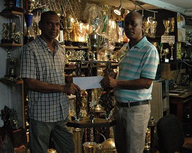 Managing Director of Trophy Stall Ramesh Sunic (left) presents the cheque and first place trophy to Three Peat Promotions Rawle Welch yesterday