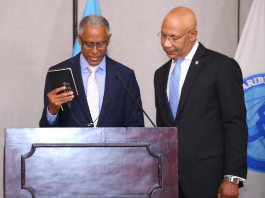 Justice Adrian Saunders (left), newly sworn-in President of the CCJ, takes the oath of office administered by Sir Patrick Allen, Governor-General of Jamaica. 
