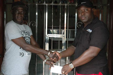 Managing Director of Shemar’s Trucking Service, Duean Boston (right) hands over the cheque to Mark Wiltshire yesterday.
