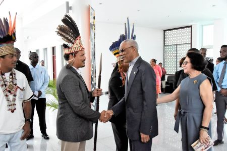 President David Granger (second from right) greeting the Vice-Chairman of the National Toshaos Council (NTC), Lennox Shuman at the opening of the NTC confab yesterday at the Arthur Chung Convention Centre, Liliendaal. At right, First Lady Sandra Granger is greeting the Chairman of the NTC, Joel Fredericks (partly hidden) (Ministry of the Presidency photo)