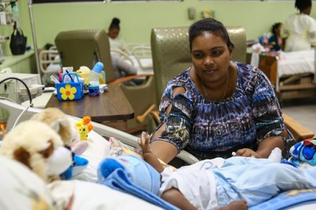Bibi Shareema Haleem, mother of one of the babies who underwent heart surgery, tends to her baby boy. (DPI photo)