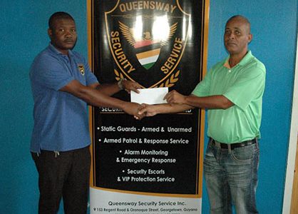 Queensway Security Services Operations Manager Clay Flatts (left) hands over the cheque to Three Peat Promotions Rawle Welch on Friday.