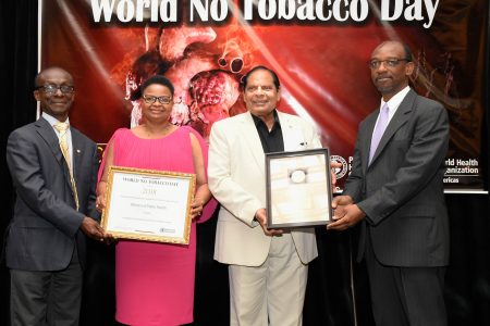 (From left) Dr. William Adu-Krow, PAHO/WHO Representative Guyana hands over the certificate of recognition to Minister of Public Health, Volda Lawrence and Prime Minister Moses Nagamootoo receives the World No Tobacco Day award from Director of Non-Communicable Diseases and Mental Health, Dr. Anselm Hennis (DPI photo).