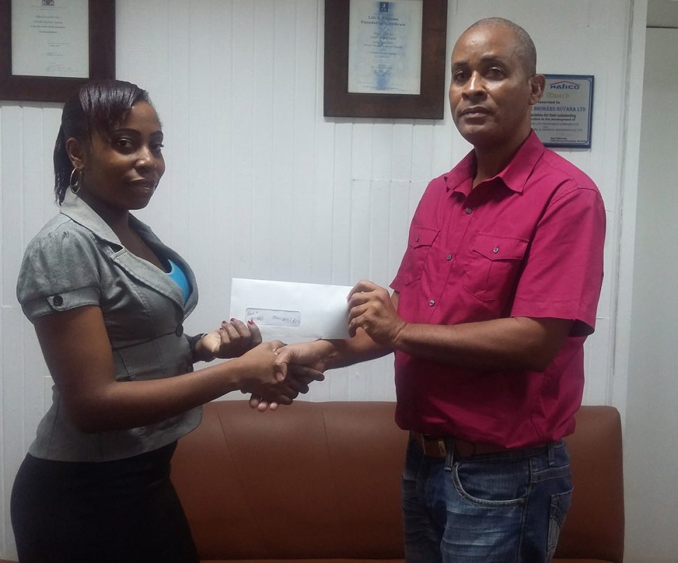 Three Peat Promotions representative, Rawle Welch, receiving the sponsorship cheque from IBGL staffer Melissa Cupidore yesterday at the IBGL Head Office in Carmichael Street.  