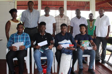 The quartet sitting, left to right, Sachin Singh, Ashmead Nedd, Qumar Torrington and Joshua Persaud, with their parents and members of the DCC. 
